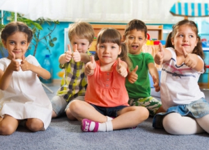 a group of pre-schoolers showing thumbs up