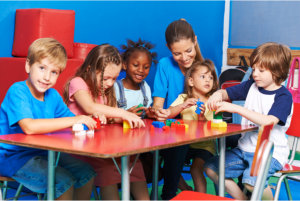 kids making an artwork with their teacher